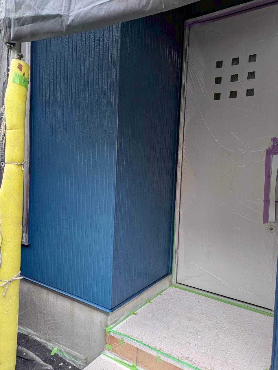 青い塗料で塗り替え完了した玄関周り